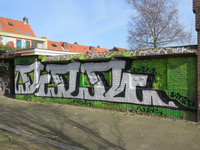 829718 Afbeelding van graffiti met een gestileerde tekst, op een muur langs het binnenterrein tussen de Aardbeistraat ...